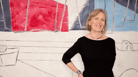 Claudia Goldin standing in front of Abstract Art