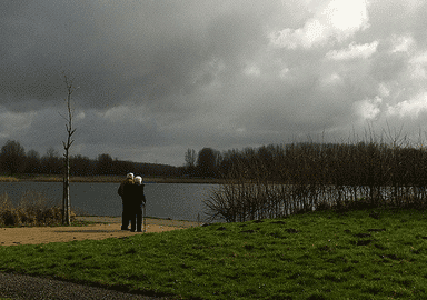 two elderly people standing together in a park