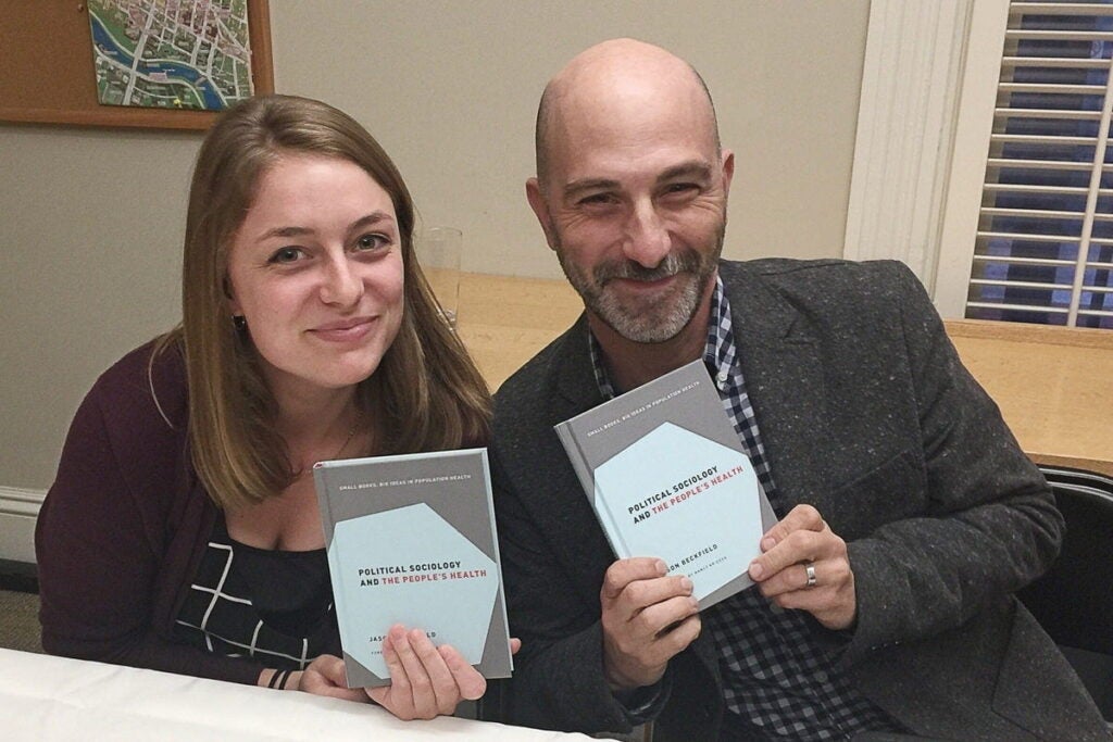 Lesley Harkins and Rob Correia hold up copies of the book
