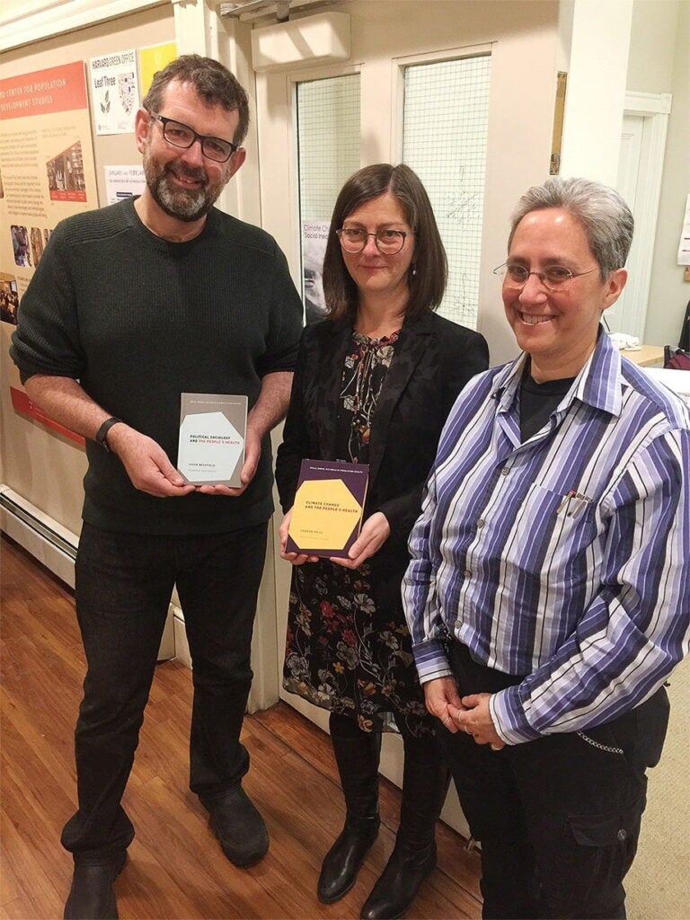Jason Beckfield holds his book, along with author Sharon Friel and series editor Nancy Krieger
