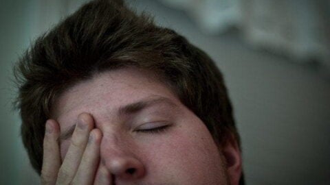 tired man rubbing his eye