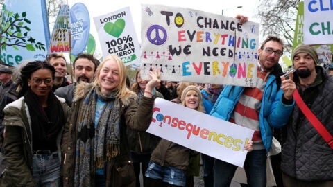 Men and women of different ethnicities with signs at a climate change rally