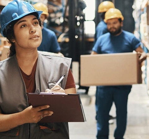Woman in warehouse with clipboard