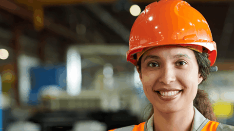 Woman wearing a hard hat in a warehouse setting