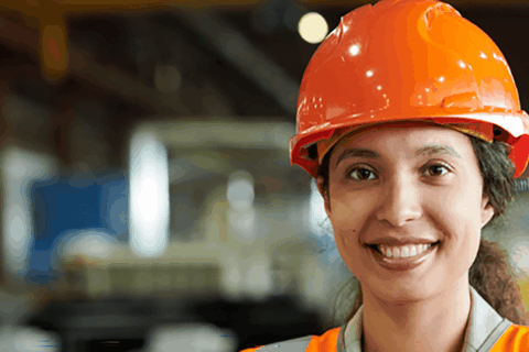 Woman wearing a hard hat in a warehouse setting
