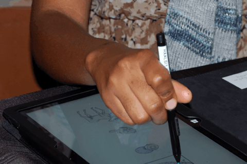 Hand holding a pen on a tablet