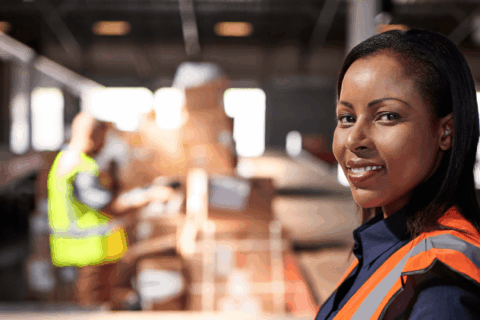 Woman working in warehouse with clipboard