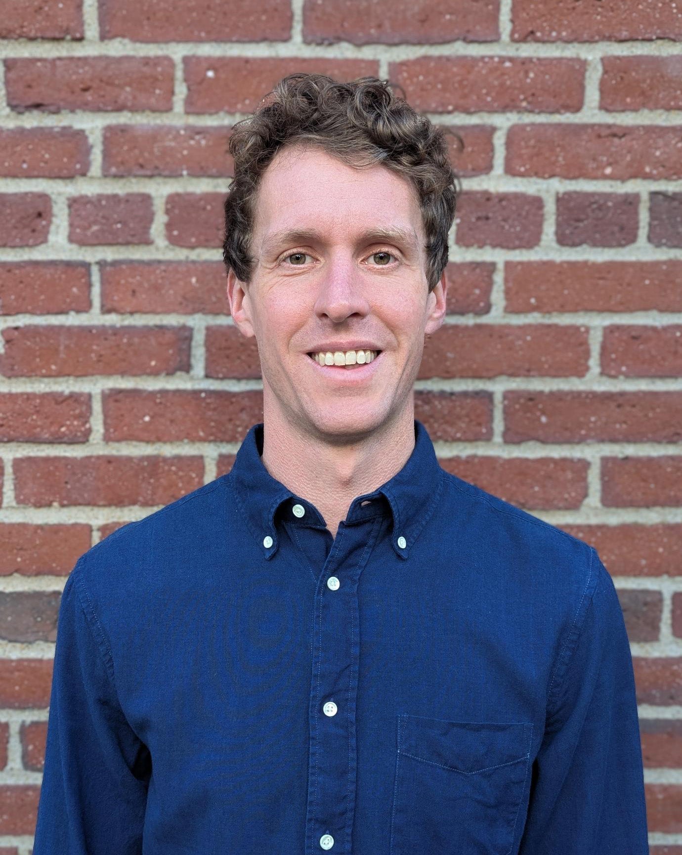 Tom Lindman standing in front of Harvard brick wall